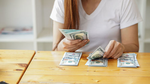 Midsection of woman holding coffee cup on table