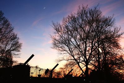 Low angle view of silhouette trees against sky at sunset