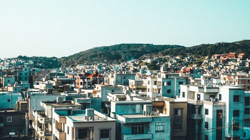 Buildings in city against clear sky