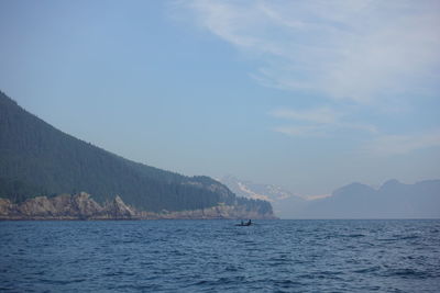 Scenic view of sea and mountains against sky