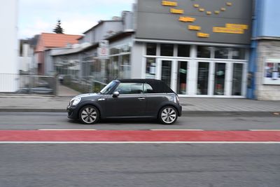 Car on street against buildings in city