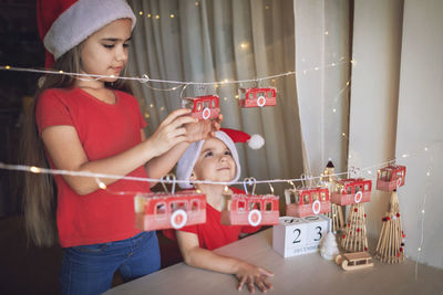 Cute sibling decorating home for christmas