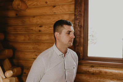 Portrait of young man standing against wall