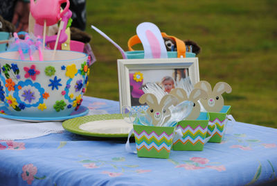 Close-up of spoons in containers with toys and picture frame on table