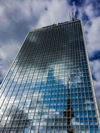 Low angle view of modern building against cloudy sky