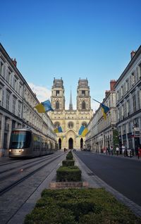 Road amidst buildings against clear sky