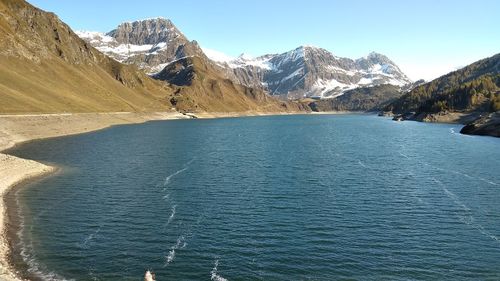 Scenic view of sea and mountains against clear blue sky