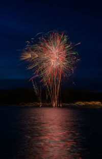 Firework display over sea at night