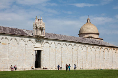 Group of people outside temple against sky