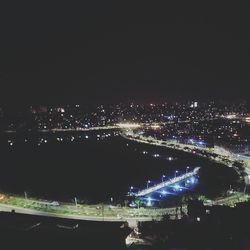 High angle view of illuminated cityscape against sky at night