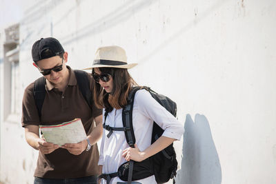 Man holding map standing with women in city