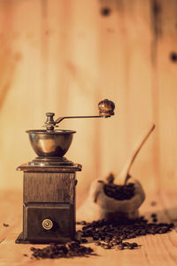 Close-up of grinder with coffee beans and spices on wooden table