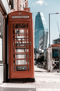 Red post box in london with skyscraper in background