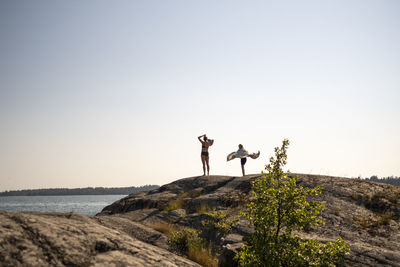 Woman and boy on rocky shore