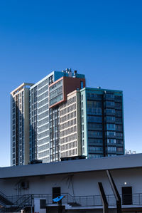 Low angle view of modern building against clear blue sky