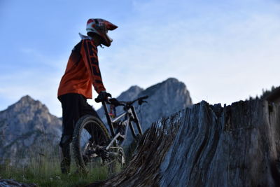 Low angle view of man with bicycle on mountain