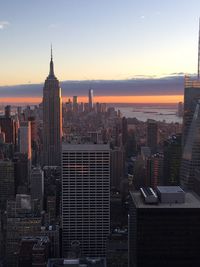 Modern buildings in city against sky during sunset