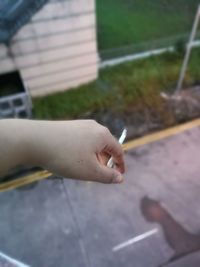 Close-up of hand holding cigarette