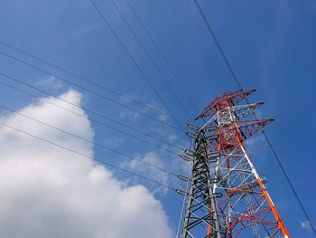 Low angle view of electricity pylon against blue sky