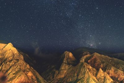 Scenic view of mountains against star field