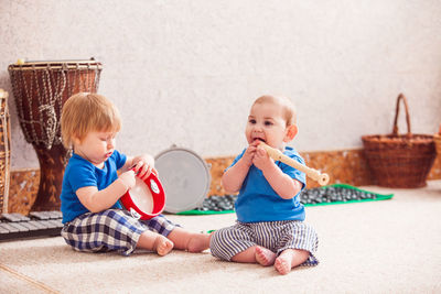 Cute brothers playing while sitting on floor