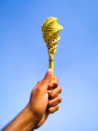 Low angle view of person holding blue sky