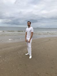 Full length of man standing on beach against sky