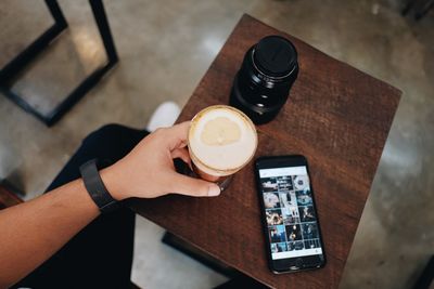 Directly above shot man holding cold coffee at restaurant table