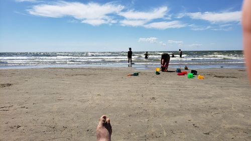 People on beach against sky