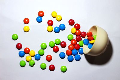 High angle view of multi colored candies against white background