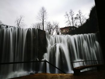 Low angle view of waterfall against sky