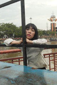 Portrait of woman sitting by water