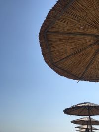 Low angle view of parasol against clear blue sky