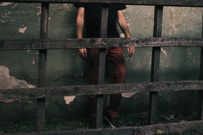 Person standing by railing against building