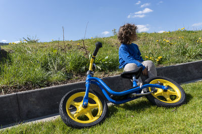 Cute boy sitting in garden with bicycle - kind mit dem fahrrad im garten