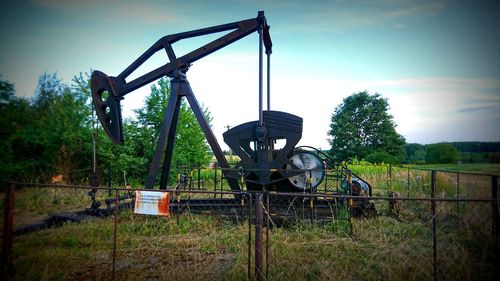 Abandoned cart on field against sky