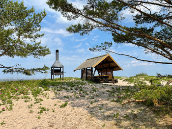 Gazebo by building on field against sky