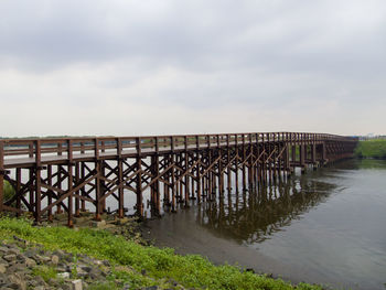 Bridge over calm sea against sky