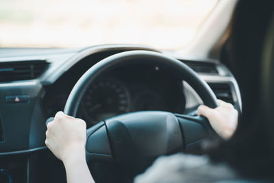 Close-up of person driving car