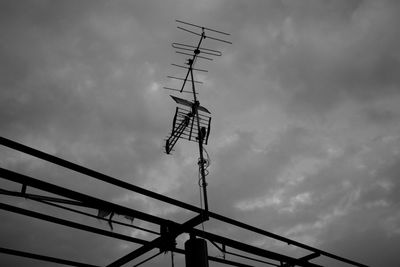 Low angle view of silhouette telephone pole against sky