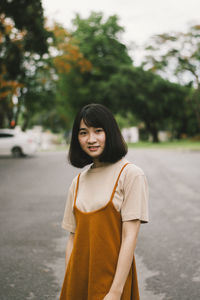 Portrait of beautiful young woman standing on street