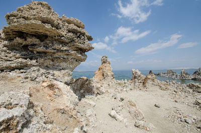 Rock formation on beach against sky