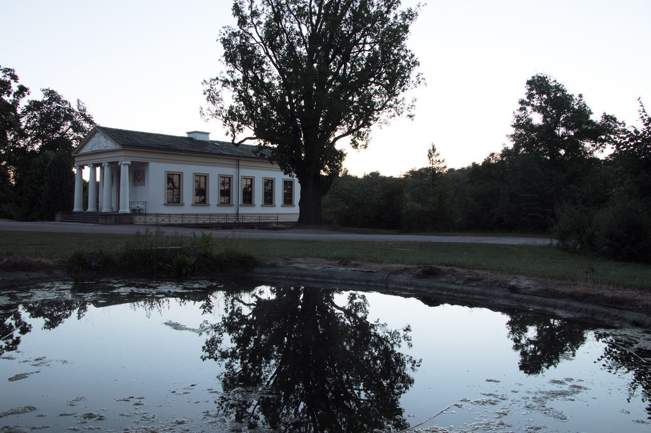 REFLECTION OF TREES AND BUILDINGS ON LAKE