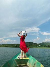 Full length of woman standing in lake against sky