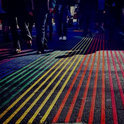 Low section of people walking on colorful patterned street