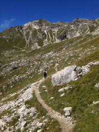 Man standing on rock against sky