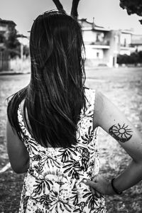 Rear view of woman standing with umbrella