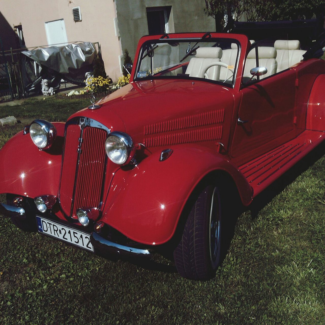 transportation, land vehicle, mode of transport, car, stationary, red, travel, parking, street, parked, day, outdoors, grass, vehicle, sunlight, no people, vintage car, high angle view, bus, road