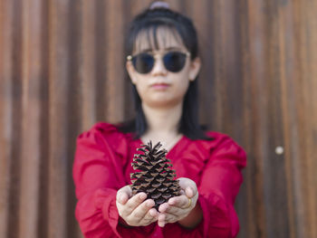 Portrait of young woman holding sunglasses