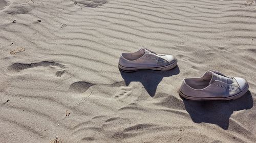 High angle view of shoes on sand at beach